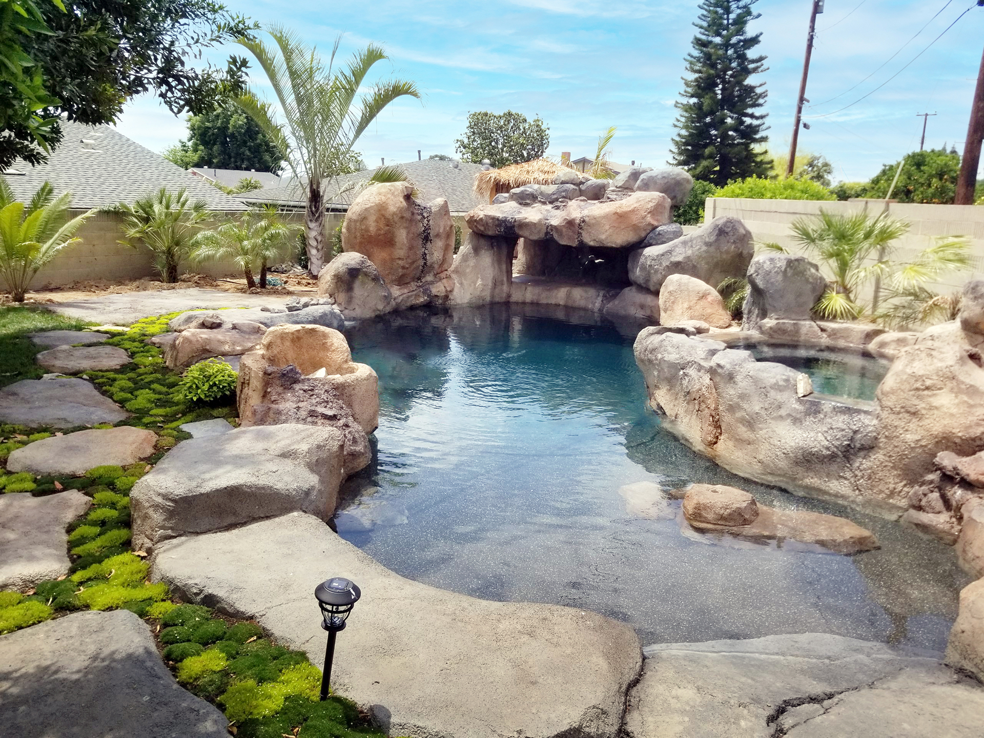 Backyard lazy river with moss-covered boulders