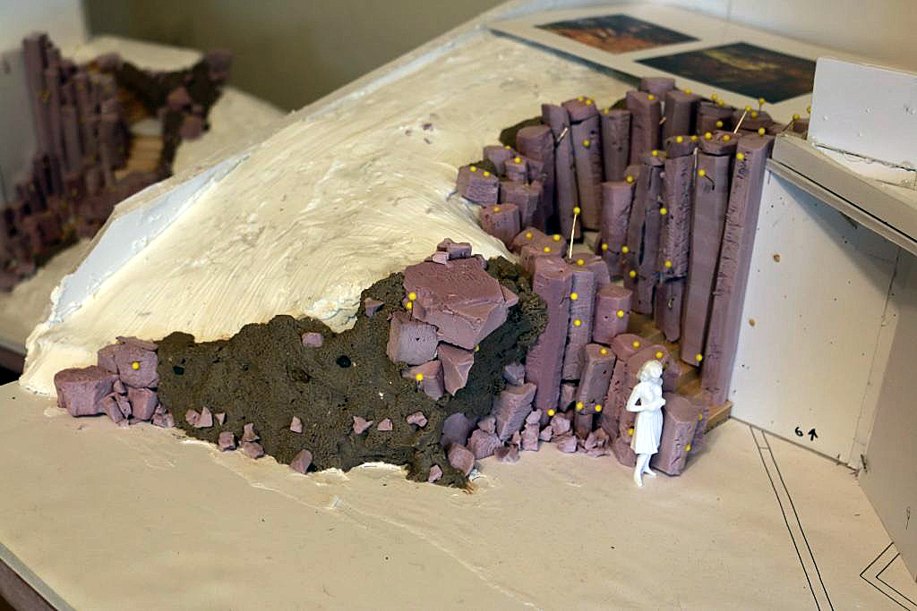 Scale model of basalt column rock formation with human figure for scale