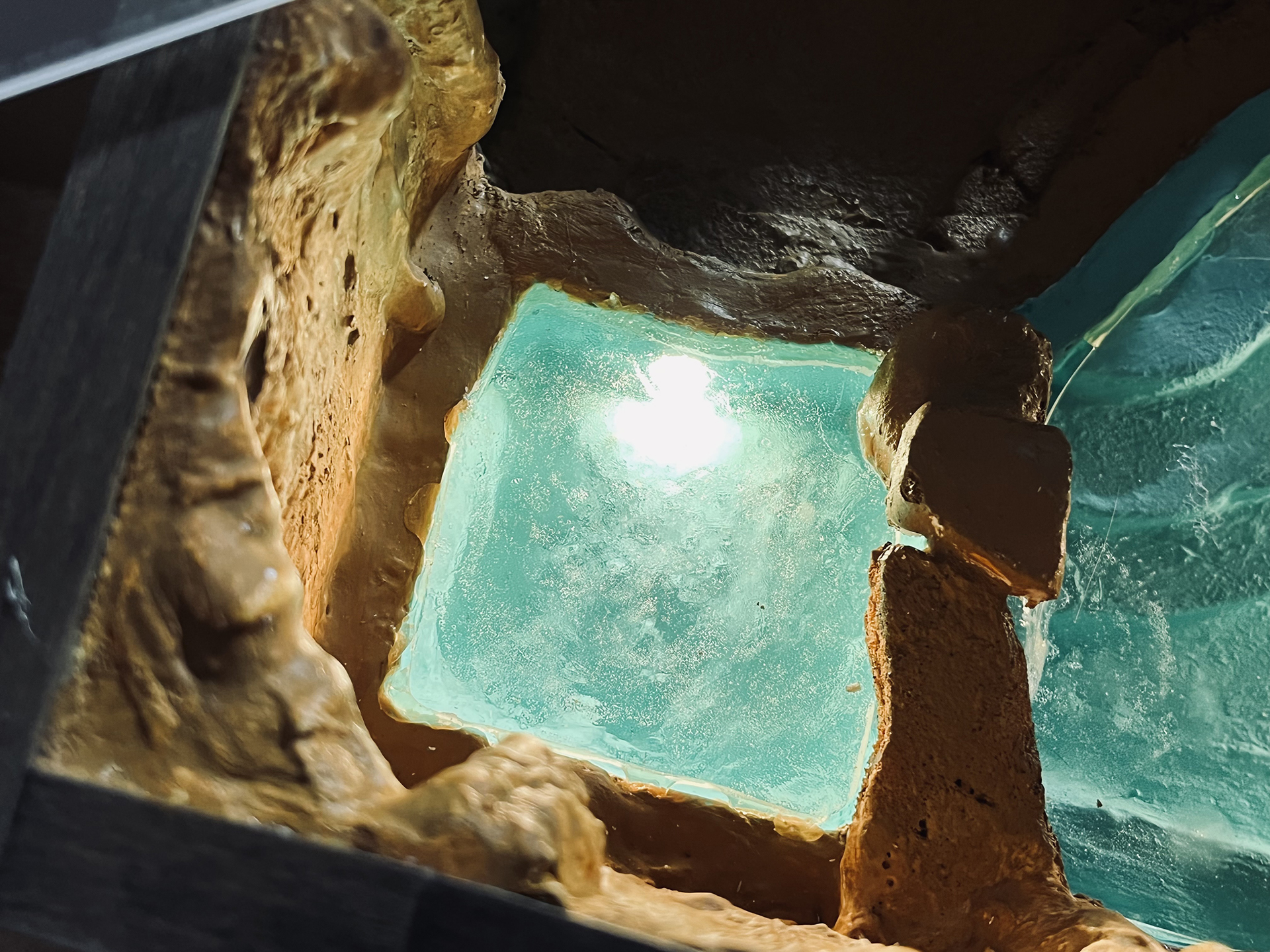 Scale model of cave grotto pool with turquoise water