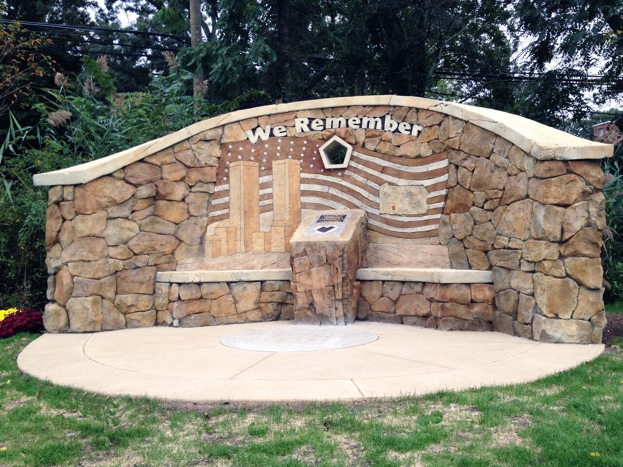 Security guard beside curved concrete monument wall