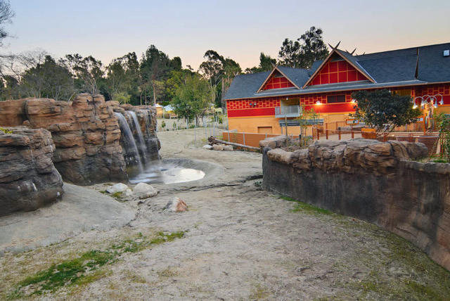 Zoo or theme park entrance at dusk with rock waterfalls